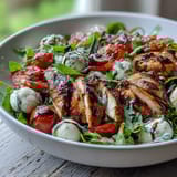A vibrant Caprese Chicken Bowl featuring grilled chicken, mozzarella, tomatoes, and basil, drizzled with balsamic reduction.