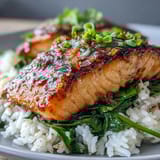 Savory Miso Glazed Salmon Bowl features tender fish with caramelized edges, served on jasmine rice alongside ginger-infused spinach and fresh scallions.