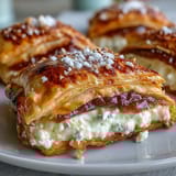Freshly baked guava and cream cheese pastelitos with a sugary crust and vibrant pink filling.