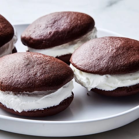 Freshly baked Whoopie Pies, a classic comfort dessert, ready to be enjoyed with a cold glass of milk.