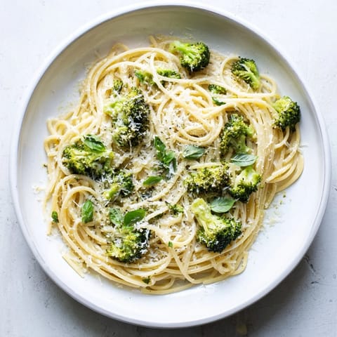 Bright One-Pot Lemon Broccoli Pasta served in a white bowl, garnished with fresh basil and grated Parmesan. 