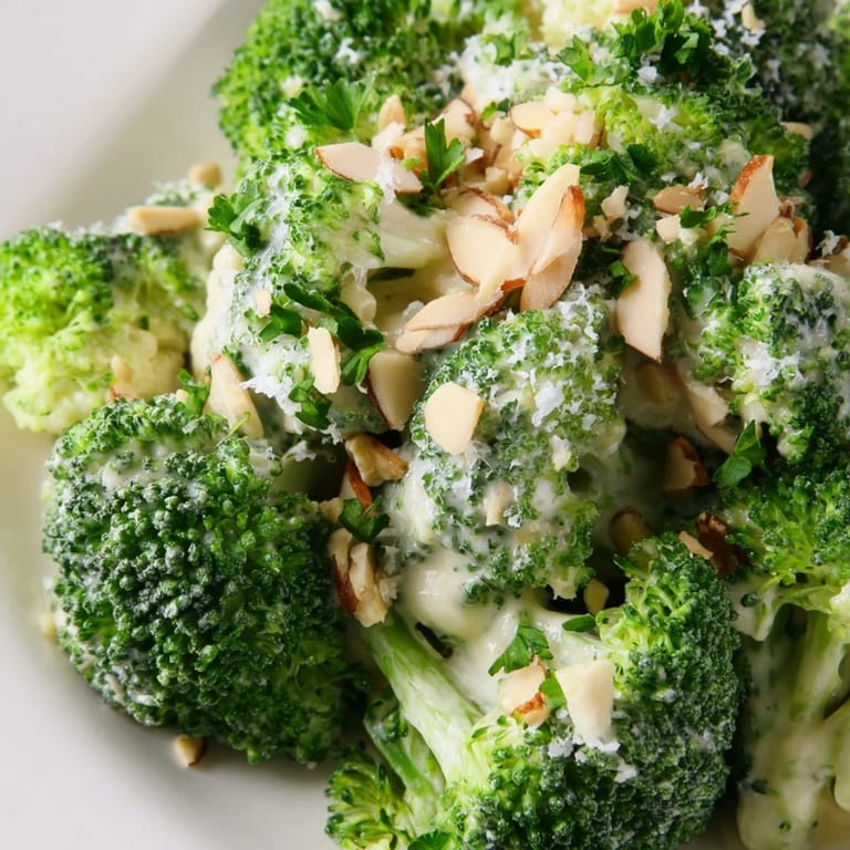 Blanched broccoli salad with red onions, cherry tomatoes, and a tangy lemon-Parmesan dressing, perfect for a light lunch.