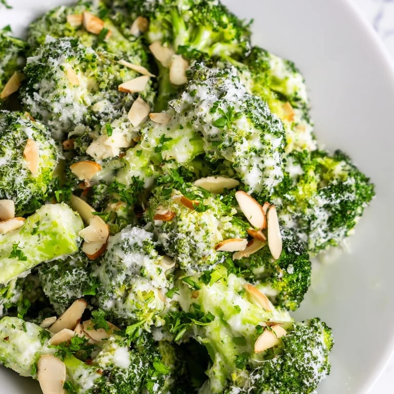 Garlic Parmesan Broccoli Salad served chilled, featuring crunchy almonds and grated Parmesan, ideal as a fresh side dish.